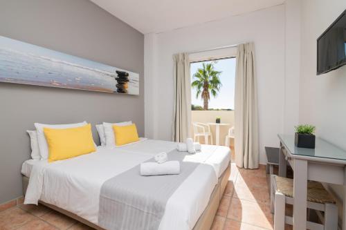 卡拉马孔Cavo Doro的卧室配有一张带黄色枕头的大型白色床。