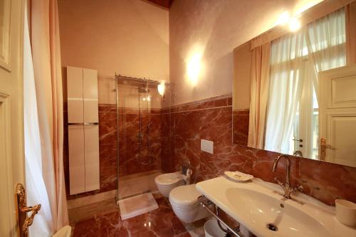 维罗纳Villa della Torre in Città的一间带水槽、卫生间和镜子的浴室