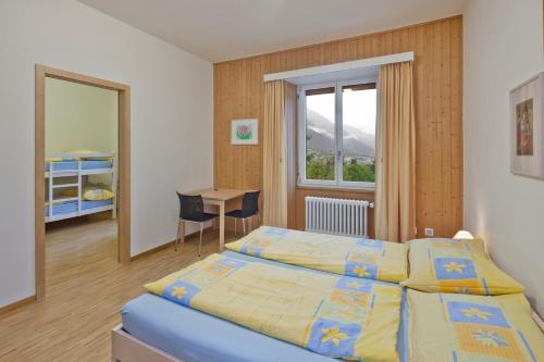 布里格Hotel Haus Schönstatt contactless-Check-In的一间卧室设有两张床、一张桌子和一个窗口