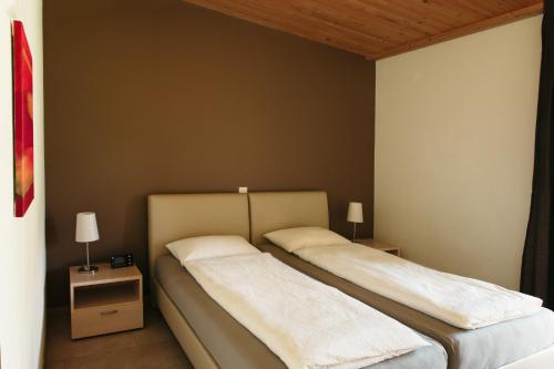 MagliasoCentro Magliaso的配有两张睡台的房间内的两张床