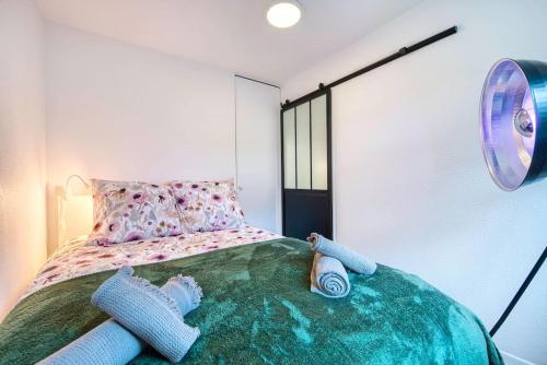 乌尔加特La Perle de Houlgate Élégance & Vue 4 pers的一间卧室配有一张带球盘和灯的床