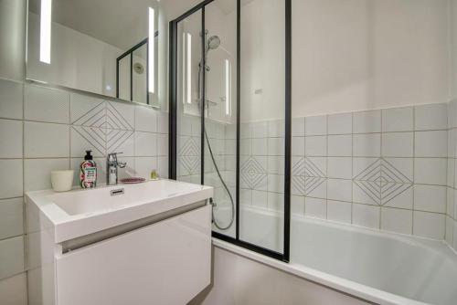 乌尔加特La Perle de Houlgate Élégance & Vue 4 pers的白色的浴室设有水槽和淋浴。