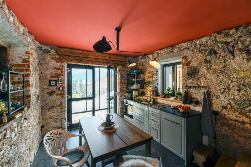 伊布斯河畔格施特灵Chalet Alte Schmiede的厨房设有红色的天花板和桌椅