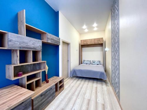 哈尔科夫Central street的一间卧室设有一张床和蓝色的墙壁