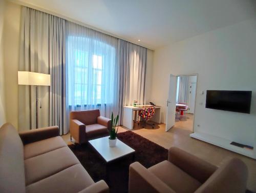 林茨阿姆多姆广场酒店 - 仅限成人入住的客厅配有两张沙发和一台电视