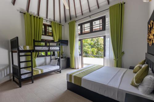康提Indra Manel Family Holiday Resort Kandy的一间卧室设有两张双层床和一扇窗户。