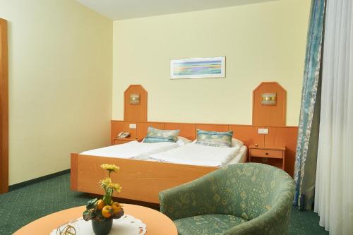 施韦夏特斯普林佐膳食公寓酒店的配有床、椅子和桌子的酒店客房