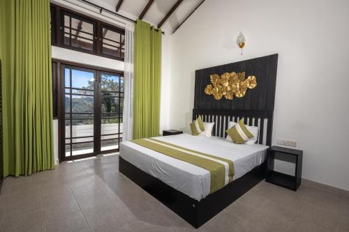 康提Indra Manel Family Holiday Resort Kandy的一间卧室配有一张带绿色窗帘的大床