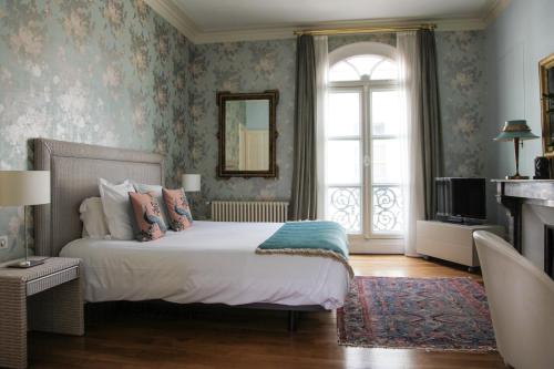 图尔儒勒豪宅酒店的一间卧室设有一张大床和一个窗户。