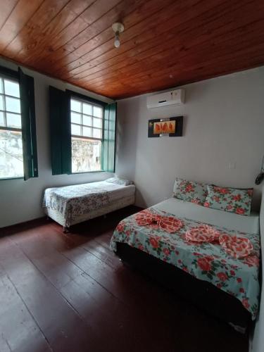 卡舒埃拉Pousada do Guerreiro的一间卧室设有两张床和两个窗户。