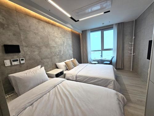 釜山Elliy's Room的酒店客房设有两张床和窗户。