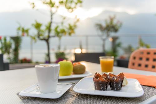 利莫内-苏尔加达Garda Suite Hotel的两盘食物和一杯茶在桌上