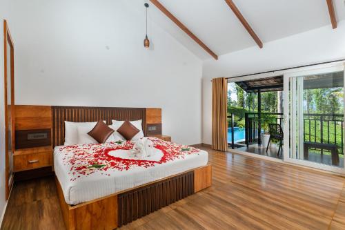 蒙纳Tealawn Pool Villa, Munnar的一间卧室,床上有红色的鲜花