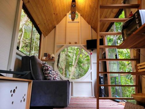 迈里波朗Tiny House da serra perto de São Paulo em meio a natureza的一间客厅,客厅配有沙发,位于一个小房子里
