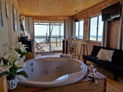 德尔迪阿布罗角NewViejoBlanco的客厅设有大浴缸,享有海景