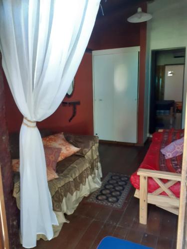 温基约CASONA DELVUELO的一间卧室配有一张带窗帘的床