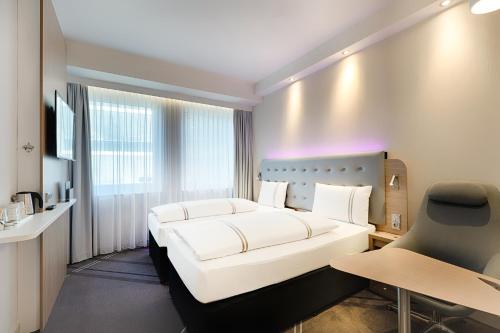 林道Premier Inn Lindau的一间酒店客房,配有一张白色的床和一张书桌
