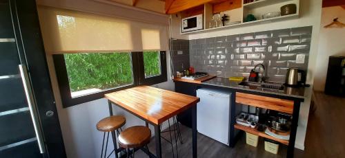 厄尔查尔坦Patagonia Tiny House的一间小房子里的厨房,里面配有桌子和凳子