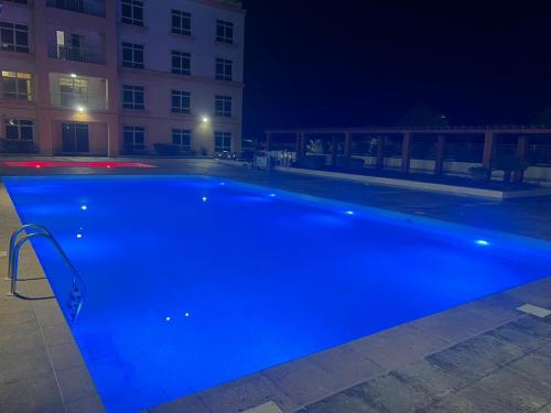 阿卜杜勒国王经济城هافانا المارينا Apartment的夜间在大楼前的蓝色游泳池