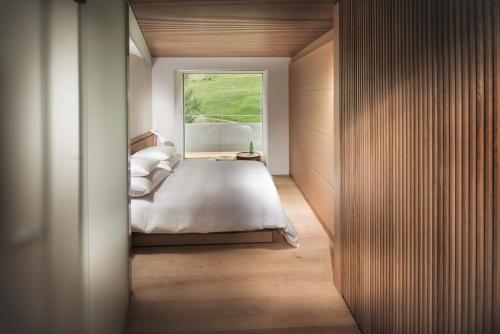 瓦尔斯House of Architects的一间卧室设有一张大床和一个窗户。