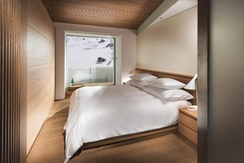 瓦尔斯House of Architects的卧室设有一张白色大床和一扇窗户。