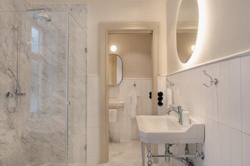 斯德哥尔摩Clas på Hörnet的白色的浴室设有水槽和淋浴。