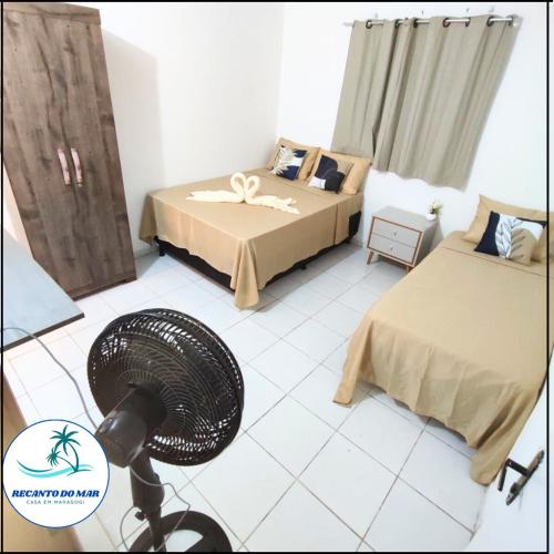 马拉戈日Recanto do Mar- Casa em Maragogi的客房设有两张床和风扇。