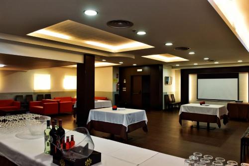 维拉加尔西亚·德·阿劳萨Hotel Alda Carril的一间设有两张桌子和投影屏幕的餐厅