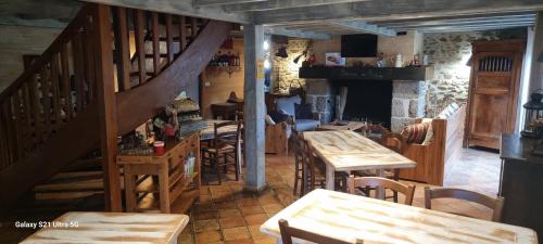 GenouillacLe Refuge的一间带木桌和椅子的餐厅,以及楼梯
