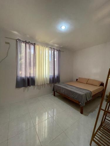 爱妮岛Buhay Probinsya - Bubolongan的一间卧室设有一张床和一个窗口