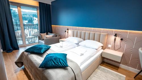 克雷尼察Apartamenty Sun & Snow Cicha的一间卧室配有一张带蓝色枕头的大床