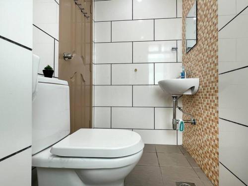 太平Comfy 2 Bedder Retreat Homestay near Taiping Lake Garden with Netflix的白色的浴室设有卫生间和水槽。
