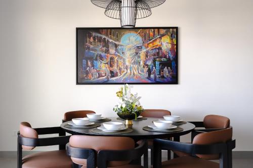 麦纳麦Fraser Suites Al Liwan的餐桌,墙上挂着绘画