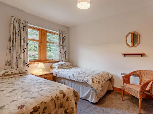 拉根3 Bed in The Cairngorms IN515的配有2张床的带窗户和椅子的客房