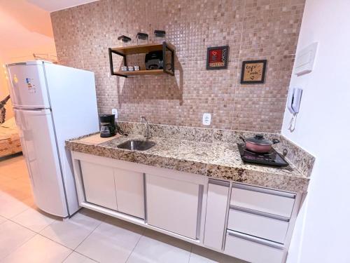 大坎皮纳Ap standard confort bem localizado的厨房配有水槽和白色冰箱