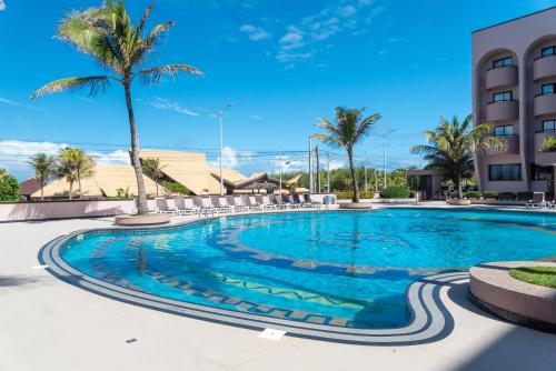 福塔莱萨加莱芙塔勒匝别墅酒店的一座棕榈树游泳池和一座建筑