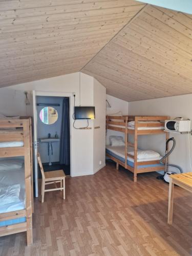 延雪平Lovsjöbadens Camping的客房设有三张双层床和一张桌子。