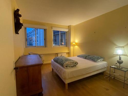 巴黎chambre privé a l'appartement partager的一间卧室配有一张床、一张桌子和两个窗户