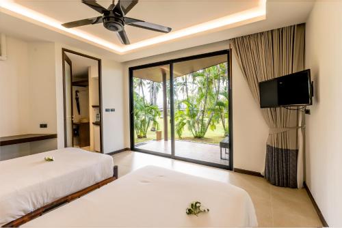 蔻立Phukhaolak Resort的一间卧室配有两张床和一台平面电视