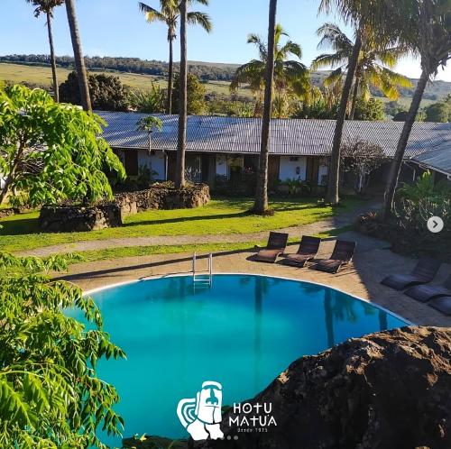 安加罗阿Hotel Hotu Matua的一座带游泳池和棕榈树的房子