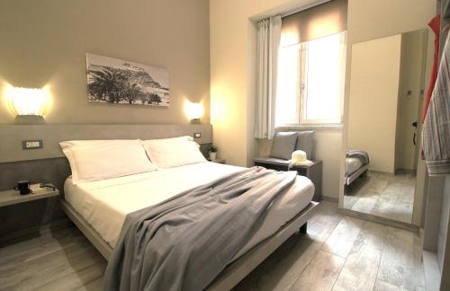 卡普多兰多Capo d'Orlando Apartments - Doria 52的一间卧室设有一张床和一个窗口