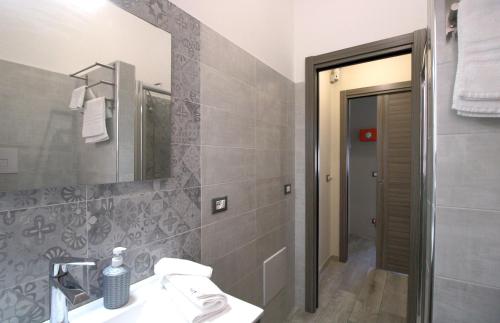 卡普多兰多Capo d'Orlando Apartments - Doria 52的一间带水槽和镜子的浴室