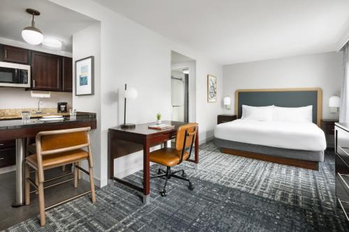 曼切斯特曼切斯特机场希尔顿惠庭套房酒店的配有一张床和一张书桌的酒店客房
