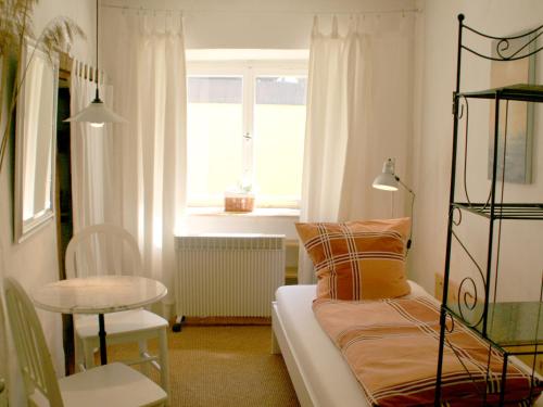 林道Ferienwohnung Altes Haus 2的客房设有床、桌子和窗户。