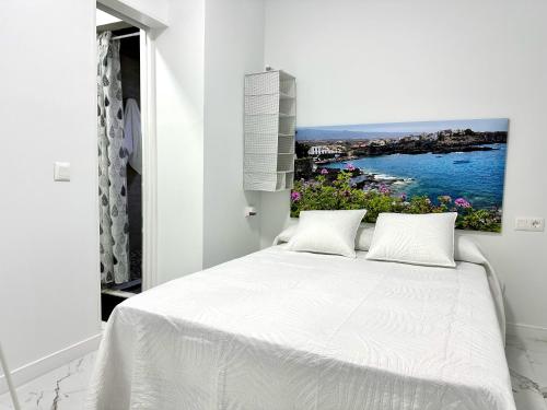 阿尔卡拉Alcalá Retreat: Ocean View & Modern Comfort的卧室配有一张白色床,墙上挂有绘画作品