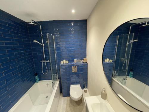 格拉斯顿伯里Globe Apartments的一间带卫生间、淋浴和镜子的浴室
