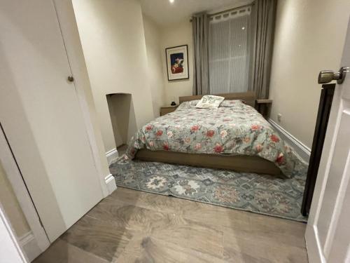 格拉斯顿伯里Globe Apartments的一间卧室配有一张带花卉棉被的床