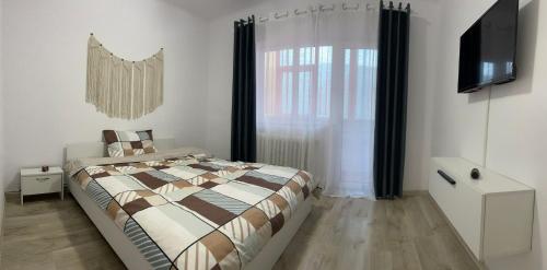 BîrladEnjoy Apartment Barlad的一间卧室设有一张床和一个大窗户