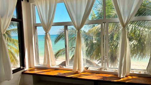 玛哈威Pronoia Casa de Playa的享有海滩景致的开放式窗户