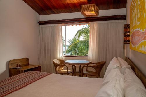 嘎林海斯港塞拉姆比度假酒店的一间卧室配有一张床、一张桌子和一个窗户。